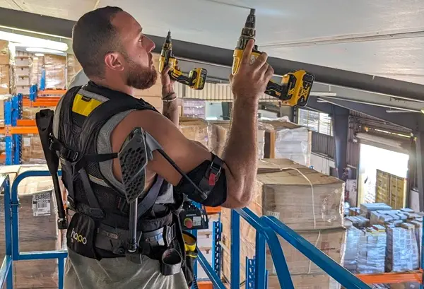 Un homme visse des plaques sur un plafond