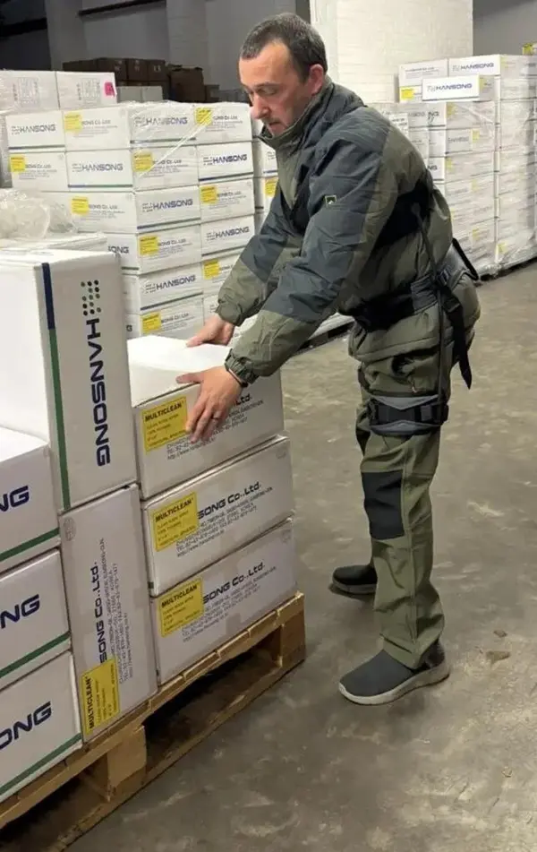 Un employ&eacute; de Lynbond range des colis sur une palette