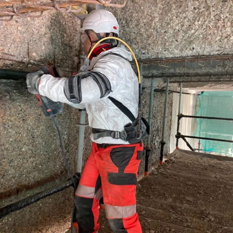 Ouvrier avec un perforateur sur un mur