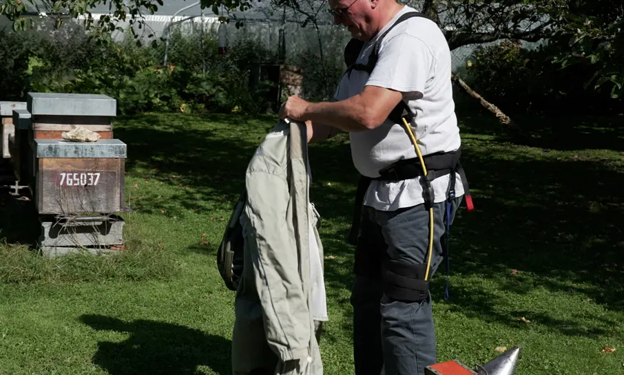 Apiculteur en train de s'équiper d'un exosquelette