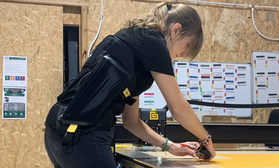 woman leaning over her work table